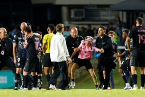 Messi knocked to ground as faithful invade field in PR